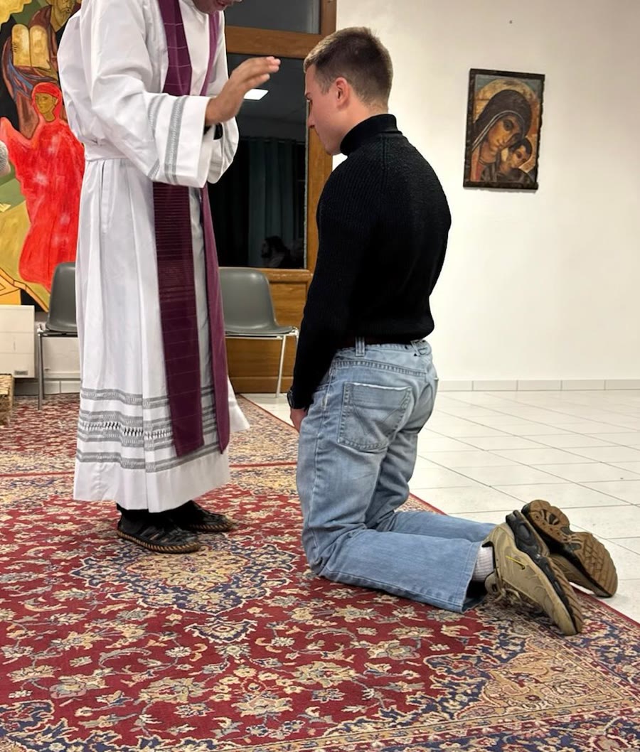 Un jeune homme agenouillé reçoit l'absolution du prêtre, qui étend la main au-dessus de lui
