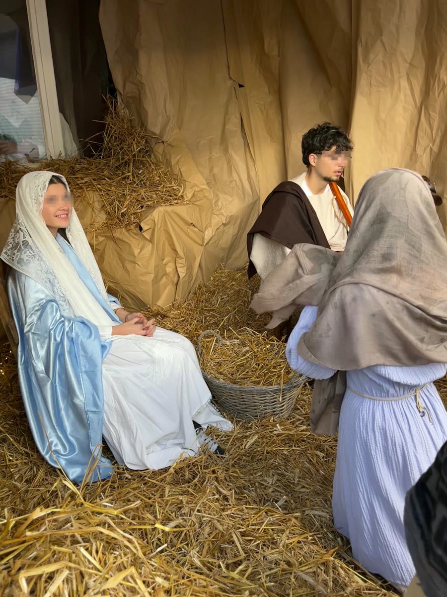 Marie, souriante, dans la crèche sur la paille
